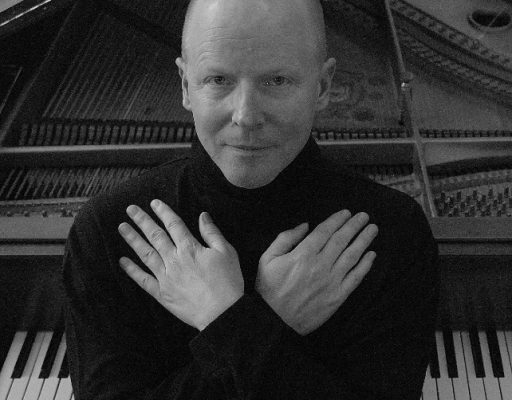 Gunnar Madsen hands crossed in front of piano